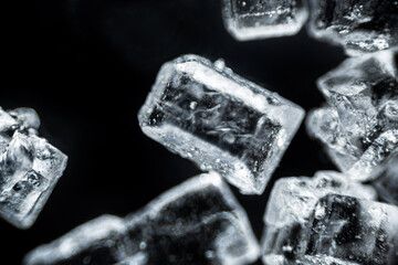 Crystal sugar macro on black background under the light microscope, magnification of 40 times,...