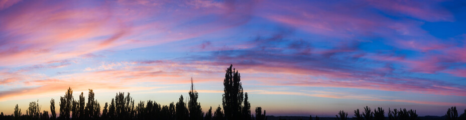 Landscape with dramatic light - beautiful golden sunset with saturated sky and clouds.