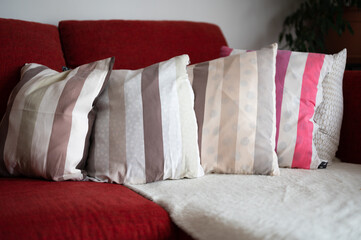 Colorful pillows lined up on red sofa, home interior