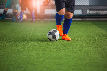 Children playing control soccer ball tactics on grass field with for training