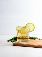 Cold fresh summer lemonade with lime and rosemary in glass