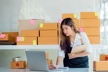 Portrait of Starting small businesses SME owners female entrepreneurs working, box and check online orders to prepare to pack the boxes, sell to customers, sme business ideas online.