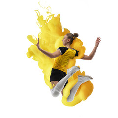 Young girl volleyball player in explosion of yellow colored neon luiquid fluid isolated on white...