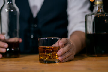 Waitress man standing pours whiskey into a glass celebrate whiskey on a friendly party in restaurant