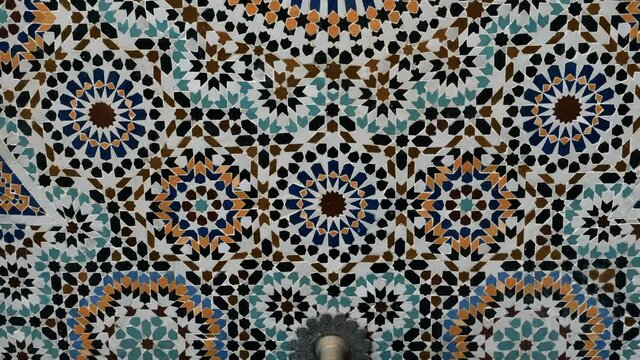 Traditional fountain in Marrakech, Morocco. Colorful star-shaped pattern in traditional Islamic geometric design, made with natural colors from indigo, saffron, mint, kohl. Camera moves up.