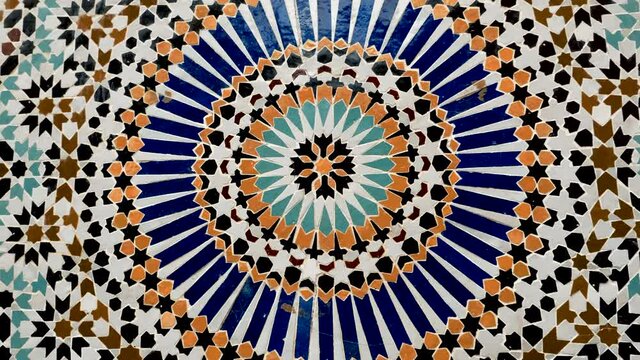Colorful zelige pattern in traditional Islamic geometric design from a public fountain in Marrakech, Morocco. Made with natural colors from indigo, saffron, mint, kohl. Camera movement zooming out.