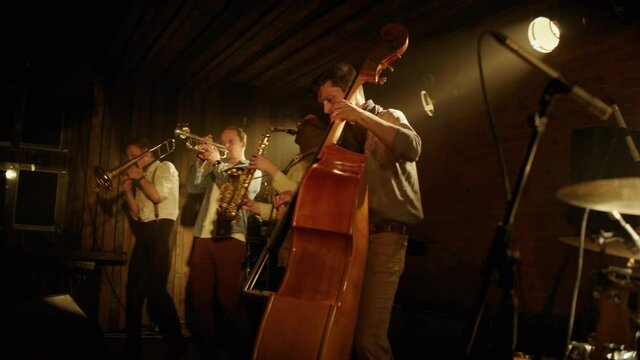 HANDHELD CU Portrait of jazz band members playing instruments on stage during a live concert in small venue. Shot on ARRI Alexa Mini with 2x anamorphic lens