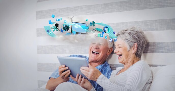 Composition of digital icons over happy senior couple using tablet in bed