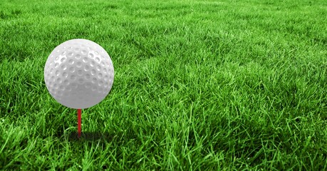 Composition of golf ball in grass on red tee, green background and copy space