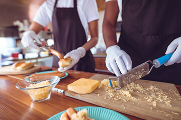 Midsection of mixed race woman grating cheese behind counter in food truck