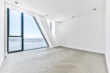 Unfurnished room interior with parquet flooring and white walls and wall window in luxury apartment © Casa imágenes