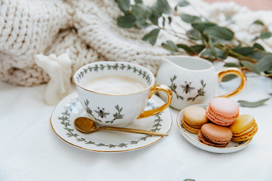 Cup of coffee and plate of macaroons on a table