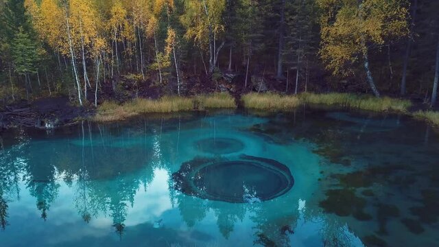 4K Aerial Footage Video of the Autumn Forest and Geyser Lake with Clear Blue Water near the village of Aktash in the Altai Mountains, Russia