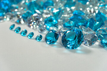 A group of aquamarine blue diamonds arranged in the middle of white diamonds on a white background..