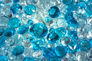 A group of aquamarine blue diamonds arranged in the middle of white diamonds on a white background..