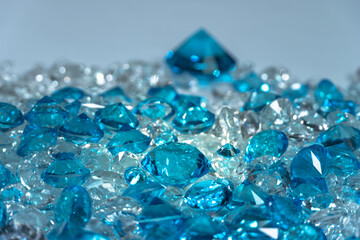 A group of aquamarine blue diamonds arranged in the middle of white diamonds on a white background..