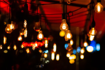 Retro light bulbs hanging from the ceiling on a terrace. Bars, pubs, cafes, cinemas and theaters...