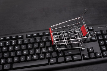 Small shopping cart on the keyboard. Online shopping concept. Supermarket trolley