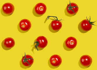 Vegetable colorful seamless pattern - ripe cherry tomato with green tail and shadow on yellow background, top view.