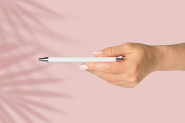 Pen in hand. Classic mock up for branding, sale and design on pink background