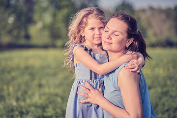 nature scene with family outdoor lifestyle. Mother and little daughter playing together in a park. Happy family concept. Happiness and harmony in family life.
