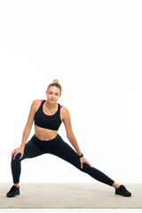 Obraz premium Young athlete woman in sportswear stretching