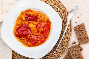 Peppers (del Piquillo) stuffed with meat or fish. Roasted red peppers and fillings made at home. Recipe of Spanish food and Mediterranean diet. With delicious sauce to spread bread and white rice.