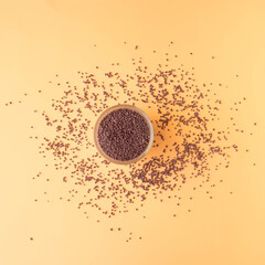 Flat lay concept on pastel beige background with colored pebbles in a jar. Minimal arrangement.