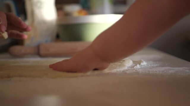 The kid touches the dough and vomits it with his finger.