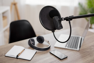 podcast and blogging concept - workplace with computer, microphone and headphones for audio content...