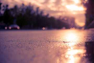 Sun after the rain in the city, view of the cars with a level of puddles on the pavement