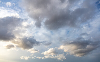 Fluffy dark clouds on blue sky background. Copy space.