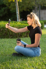 Young blonde woman sitting in the park