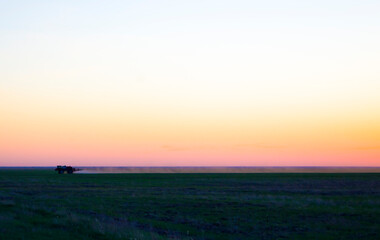 Fototapeta premium The tractor pollinates the fields from the weeds. Field chemical field, Chemical field treatment.