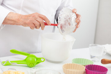 Senior woman preparing dough for a delicious cheese and ham tartlet