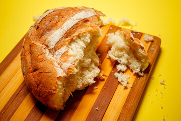 bread on a wooden board on a yellow background