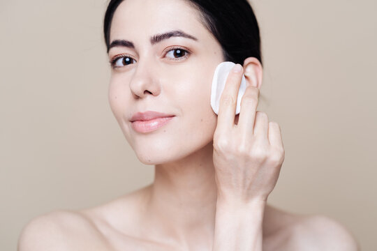 Beautiful Caucasian Woman Gently Cleaning Face With Makeup Remover Pad Ion Beige Background