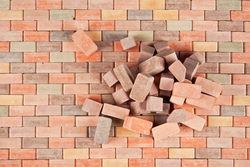 Fototapeta premium Colorful bricks on a pile. Brick texture close up. The blocks are stacked on brick paving.