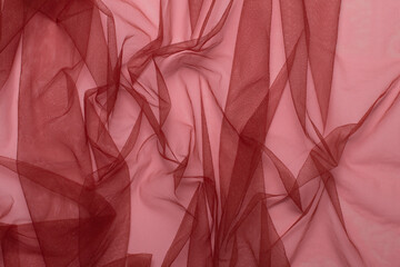Texture of wrinkled, crumpled burgundy tulle fabric close-up. background for your mockup