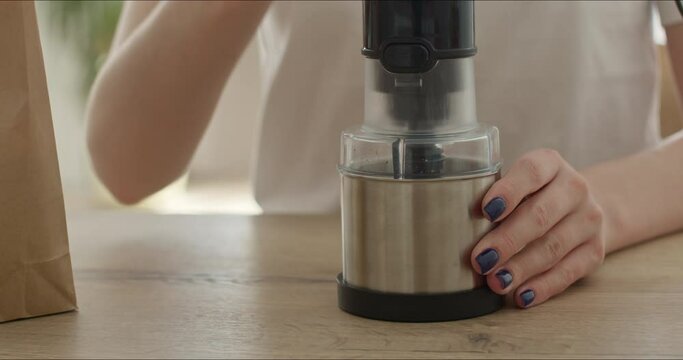 young woman grinding coffee beans