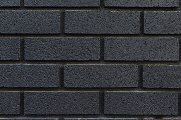 Black brick wall texture background close-up.