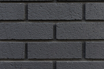 Black brick wall texture background close-up.
