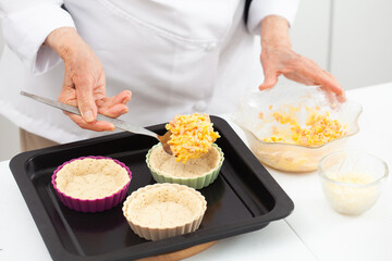 Senior woman preparing a delicious cheese and ham tartlet