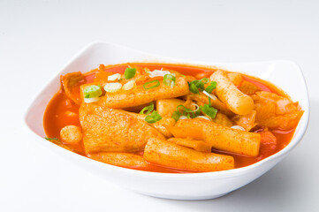 Asian tofu and rice noodles in a kimchi sauce at a Korean restaurant.  White background.  ........
