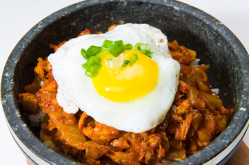 Asian chicken in a spicy sauce with a fried egg in a hot pot at a Korean restaurant.  White background.  ........