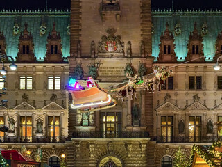 Hamburg, Germany. Flying Santa Claus on background of Hamburg Town Hall. Latin motto on facade reads: The freedom won by our elders, may posterity strive to preserve it in dignity.