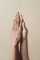 Multiethnic couple holding hands. Young Caucasian woman and African male arms together on beige background. Family Success concept