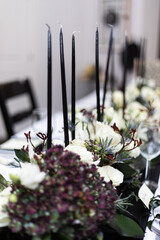 White roses and dark purple accents in floral centerpiece