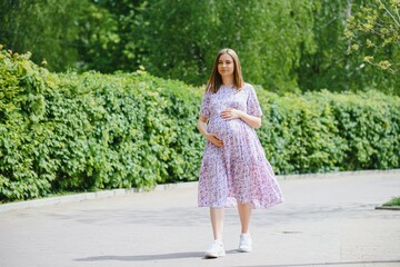 The pregnant girl on walk in city park