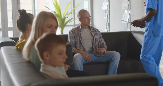 Nurse inviting mature male patient in doctor office in clinic